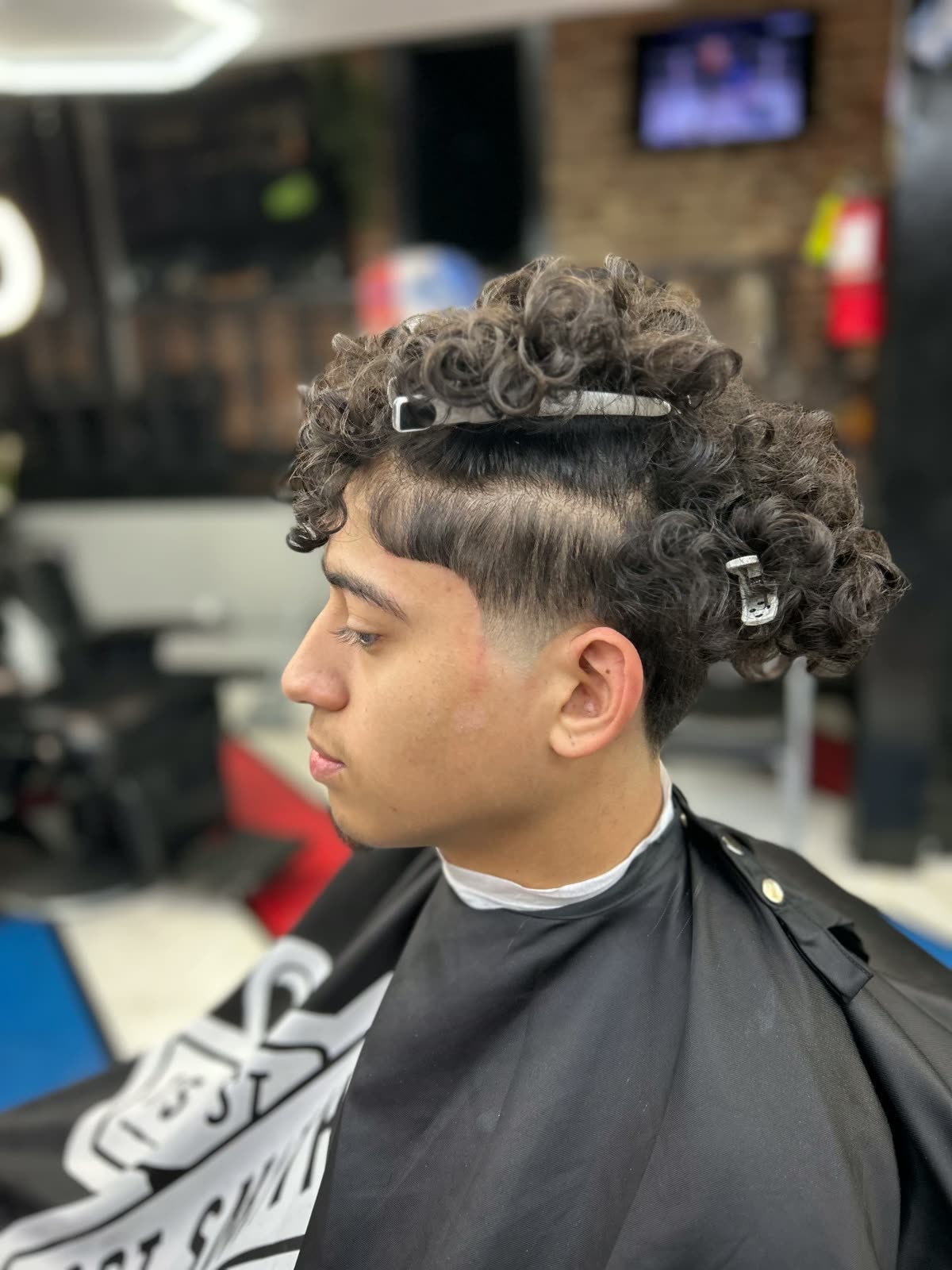 Curly top with a clean mid fade